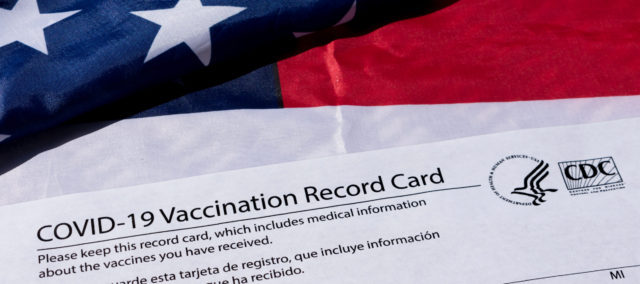 Vaccine card and American flag
